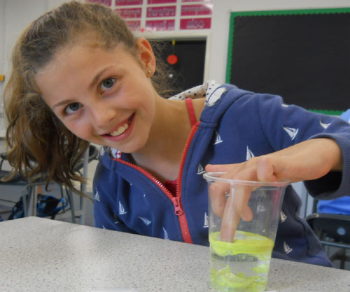 A student explores the properties of hydrophobic sand in the transition workshop from Thinkers in Education